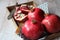 Three beautiful red pomegranates, pomegranates on a tray, pomegranate seeds, a colored napkin, pomegranate seeds