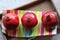 Three beautiful red pomegranates, pomegranates on a tray, pomegranate seeds, a colored napkin, pomegranate seeds