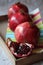 Three beautiful red pomegranates, pomegranates on a tray, pomegranate seeds, a colored napkin, pomegranate seeds