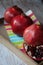 Three beautiful red pomegranates, pomegranates on a tray, pomegranate seeds, a colored napkin, pomegranate seeds