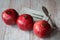 Three beautiful red pomegranates, pomegranates on a tray, pomegranate seeds, a colored napkin, pomegranate seeds
