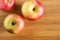 three beautiful red-yellow apples lying on a wooden triangle background