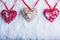 Three beautiful romantic vintage hearts are hanging on a red band on a white snow background. Love and St. Valentines Day concept.