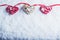 Three beautiful romantic vintage hearts are hanging on a red band on a white snow background. Love and St. Valentines Day concept.