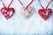 Three beautiful romantic vintage hearts are hanging on a red band on a white snow background. Love and St. Valentines Day concept