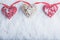 Three beautiful romantic vintage hearts are hanging on a red band on a white snow background. Love and St. Valentines Day concept.