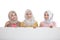 Three beautiful siblings holding a white board while pointing at