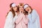 Three beautiful young girls 20s wearing colorful striped pyjamas