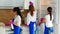 Three beautiful young girls stand with their backs and do the cleaning of the kitchen. Sink chill, oven and cupboards.