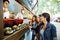 Three beautiful young women buying meatballs on a food truck.