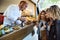 Three beautiful young women buying meatballs on a food truck.