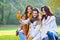 Three beautiful young women in the park taking a photo