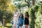 Three beautiful young women walking in summer park after shopping. Group of international people