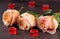 Three beige rose with candles in the shape of heart on a dark wooden background