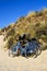 Three bicycles parked against sand dunes