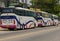 Three big travel buses were parking near the street.