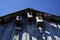 Three birdhouses under the roof of the house against the blue sky