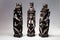 Three black-carved sculptures,