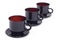 Three black cup and saucer on a diagonal