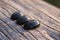 Three black jade translucent gemstones on wood