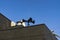 Three black modern megaphones loudspeaker on the building roof over blue sky