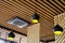 Three black pendant lamps and ceiling air conditioner in a wooden interior. Yellow lights hang overhead