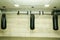 Three black punching bags in the empty boxing gym with naked grunge wall in background.