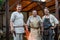 Three blacksmiths posing in front of a workshop in the open air.