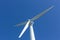 Three bladed wind turbine against cloudless blue sky