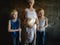 Three blonde brothers pose in Studio next to their mother. Boys and a woman with white bleached hair. family is happy together