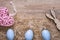 Three blue eggs with straw and feathers and pink heart with bunny