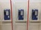 Three blue public telephones on white counter