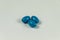 Three blue soft gelatine capsules.