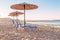 Three blue sunbed, straw umbrella on beautiful beach background