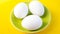 Three boiled eggs on green plate