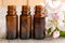 Three bottles of essential oil with apple blossoms