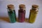 Three bottles with red  green  yellow glitter on white background. Top view. Hobby  decor ingredient.