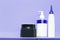 Three bottles of shampoo or shower gel, cream dispenser on colored background with copy space