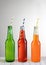 Three bottles of soda with Straws on a wood table, Lemon-Lime, Strawberry and Orange flavors