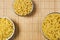 Three bowls of dried pasta on a cane tablecloth