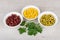 Three bowls with green peas, beans, sweet corn and parsley