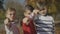 Three boys pointing fingers at the camera. Brothers spend time together outdoors. Focus moves from the foreground to the