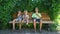 Three boys sitting in park and eating ice cream