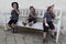 Three boys sitting on white bench having ice cream