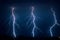 Three branched lightning bolts next to each other strike down to earth from a severe summer thunderstorm in The Netherlands
