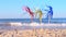 Three bright shiny colored cocktail decorations stand in sand near sea close-up.