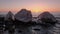 Three brothers rock on the beach at sunset hour.