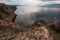 Three Brothers Rocks on Olkhon Island on Lake Baikal on a cloudy day with mountains on the horizon.