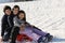 Three brothers on the sled in the snow in winter