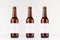 Three brown longneck beer bottles 330ml with blank white label on white wooden board, mock up.